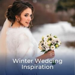 Bride in white holding white winter flowers - link to Winter Wedding Ideas featured article